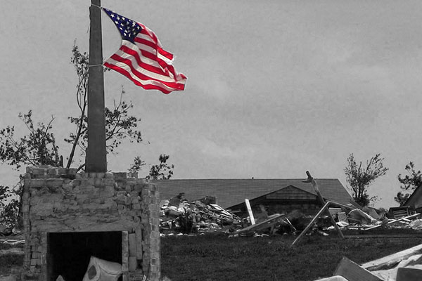 American Flag waving in the wreckage of a tornado
